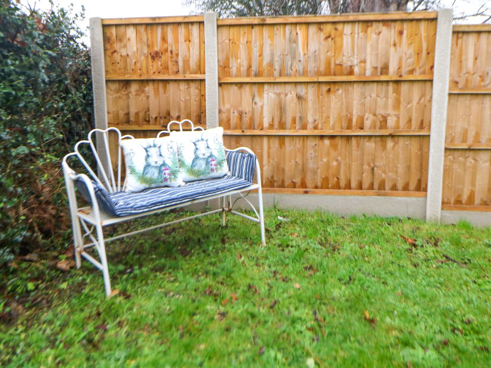 A bench with decorative cushions in a garden at Nightingale House Stafford