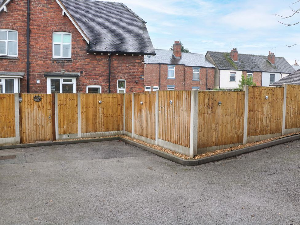 An outdoor area with wooden fences and houses in the background at Nightingale House Stafford