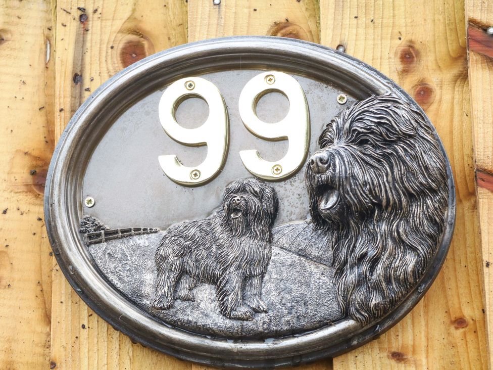 A house number sign with the number 99 and dog sculptures at Nightingale House Stafford