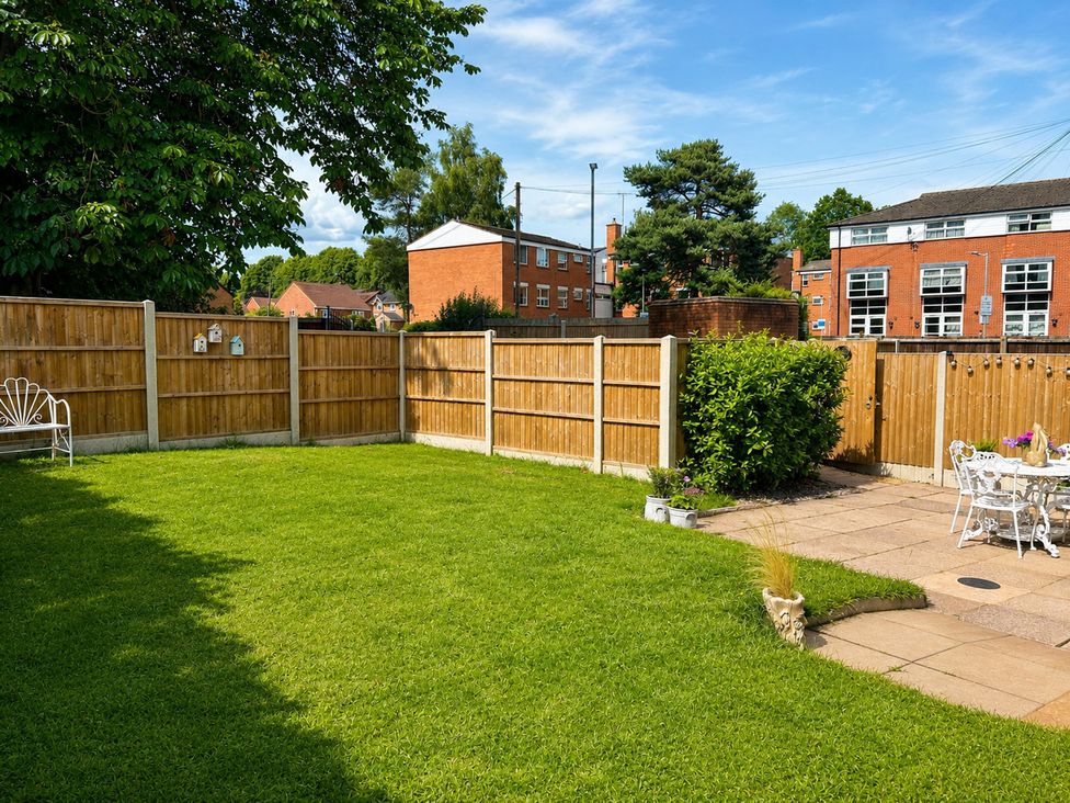 A garden with a fence and garden furniture at Nightingale Cottage Stafford