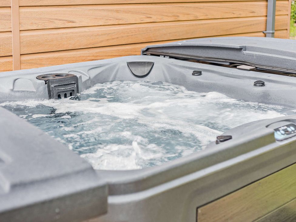 A hot tub with water and jets in an outdoor area at Saron 2.0 Spa Pet, Llandyrnog