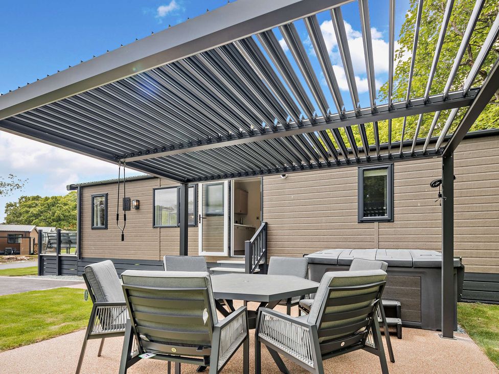 A garden area with seating and a hot tub at Saron 2.0 Spa Pet in Llandyrnog