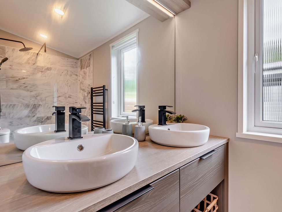 A bathroom with sinks and mirrors at Saron 2.0 Spa Pet in Llandyrnog