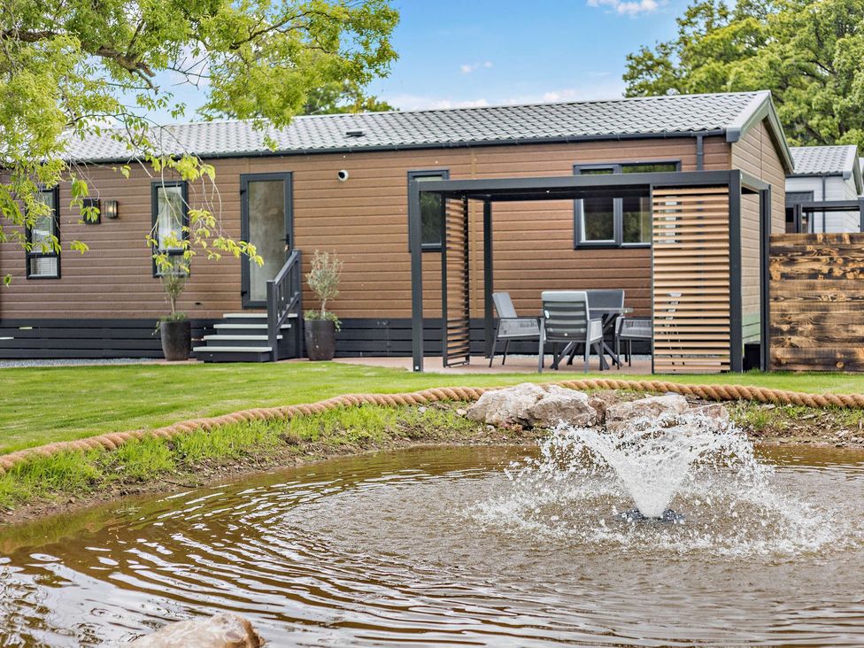 An outdoor area with a house and fountain at Saron 2.0 Pet in Llandyrnog