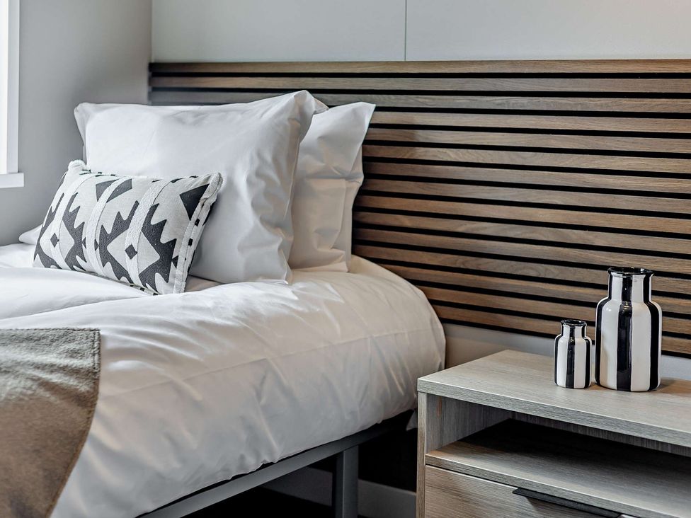 A bedroom with a bed and nightstand at Saron 2.0 Pet in Llandyrnog