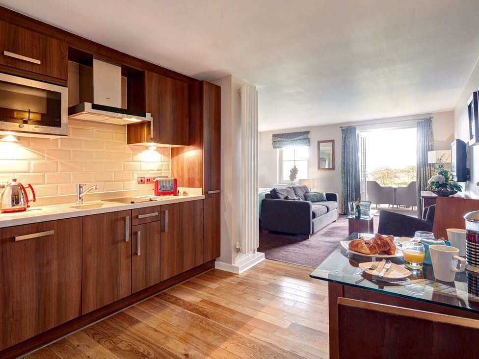 A kitchen and living room area with a sofa and dining table at Fell View Apartment in Penrith