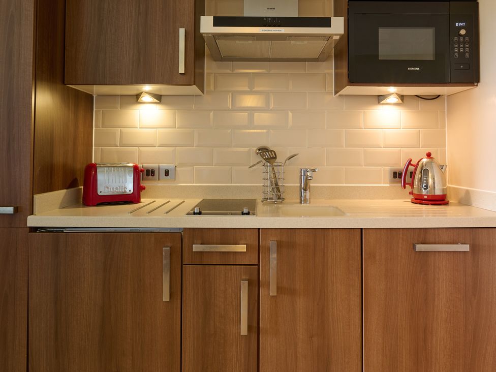 A kitchen with a sink, toaster, kettle, and microwave at Fell View Apartment in Penrith