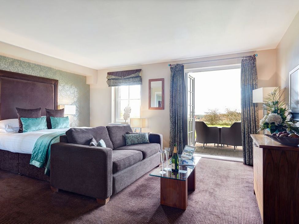 A bedroom with a bed and seating area at Fell View Apartment in Penrith