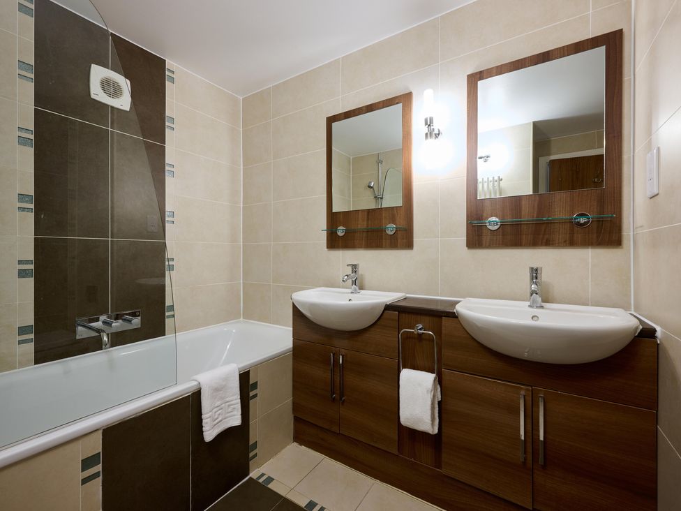 A bathroom with a bathtub and two sinks at Fell View Apartment in Penrith