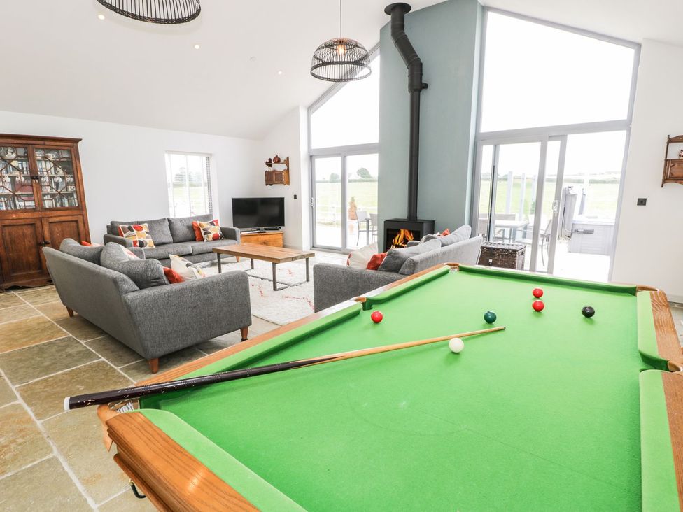 A living room with a pool table and seating area at Cae Sam in Pentraeth