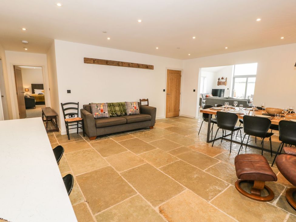 A living room with a sofa and dining table at Cae Sam in Pentraeth