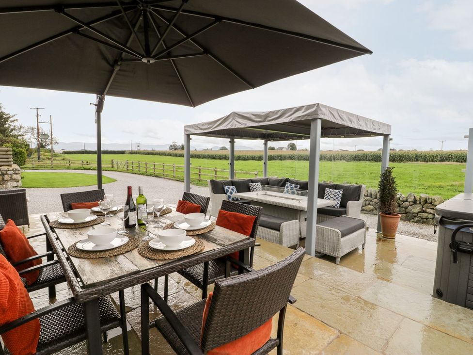 An outdoor dining area with a table and chairs at Cae Sam in Pentraeth