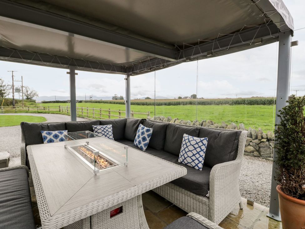 An outdoor seating area with a sofa and table at Cae Sam in Pentraeth