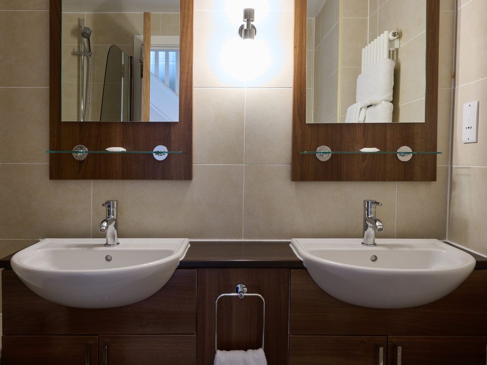 A bathroom with double sinks and mirrors at Duplex Apartment in Penrith