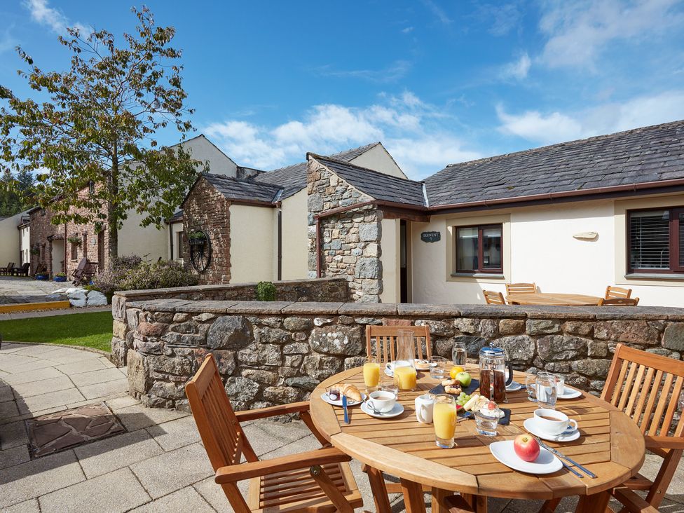 An outdoor dining area with a table set for breakfast at Derwent (Pet) Penrith