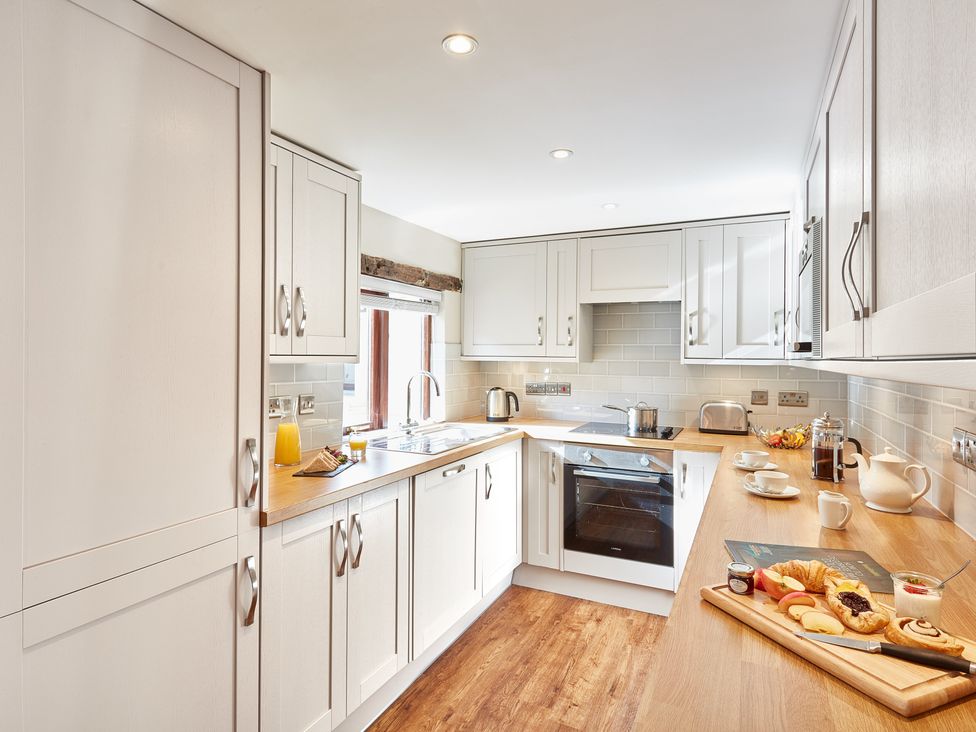 A kitchen with appliances and food items at Derwent (Pet) Penrith