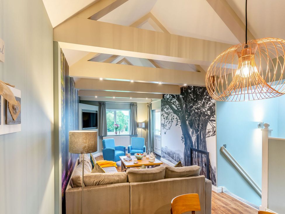 A living room with a sofa and coffee table at The Whitbarrow Den in Penrith