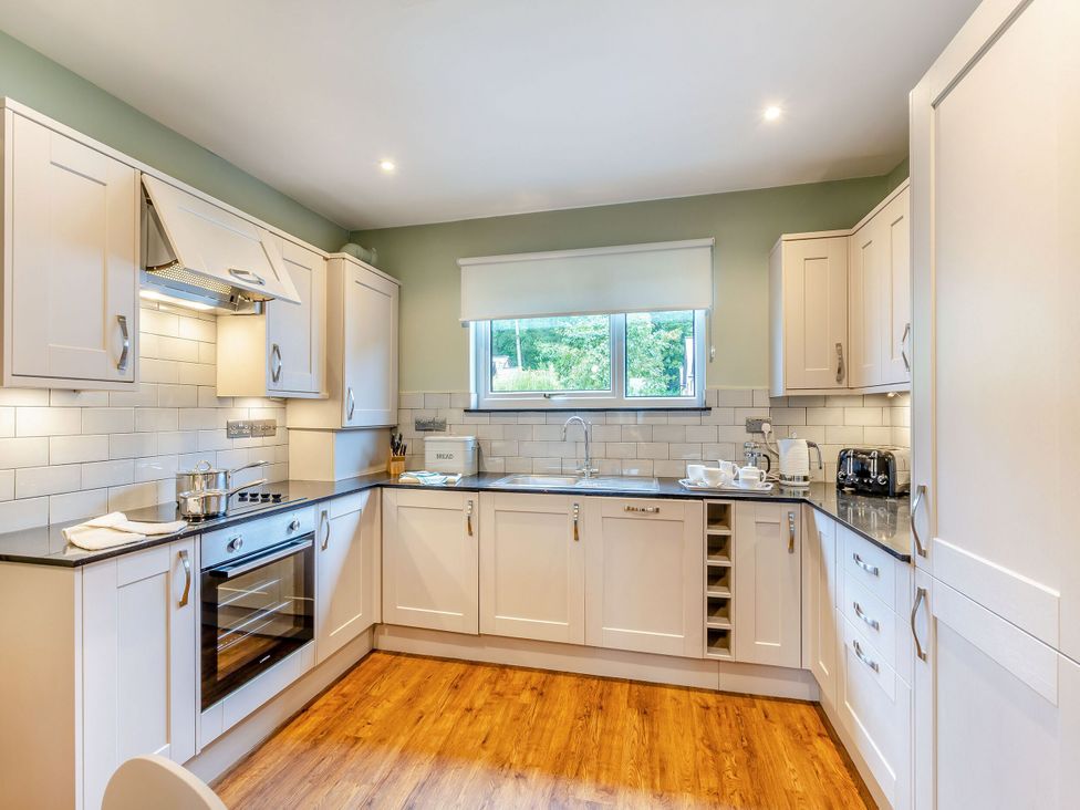 A kitchen with cabinets and appliances at The Whitbarrow Den in Penrith
