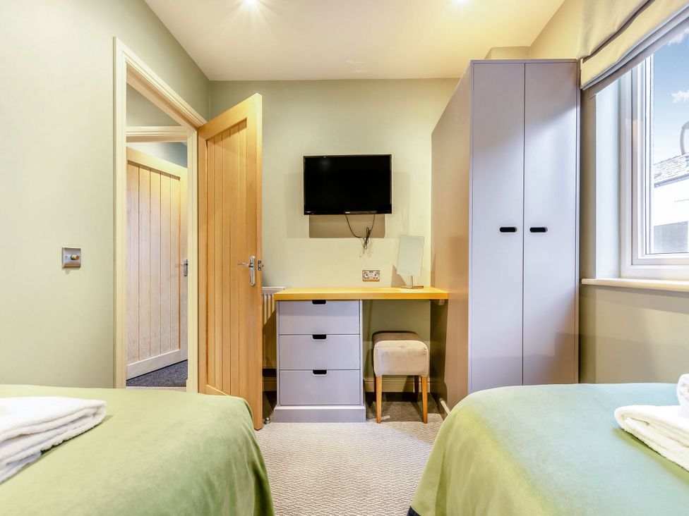 A bedroom with a desk and television at The Whitbarrow Den in Penrith