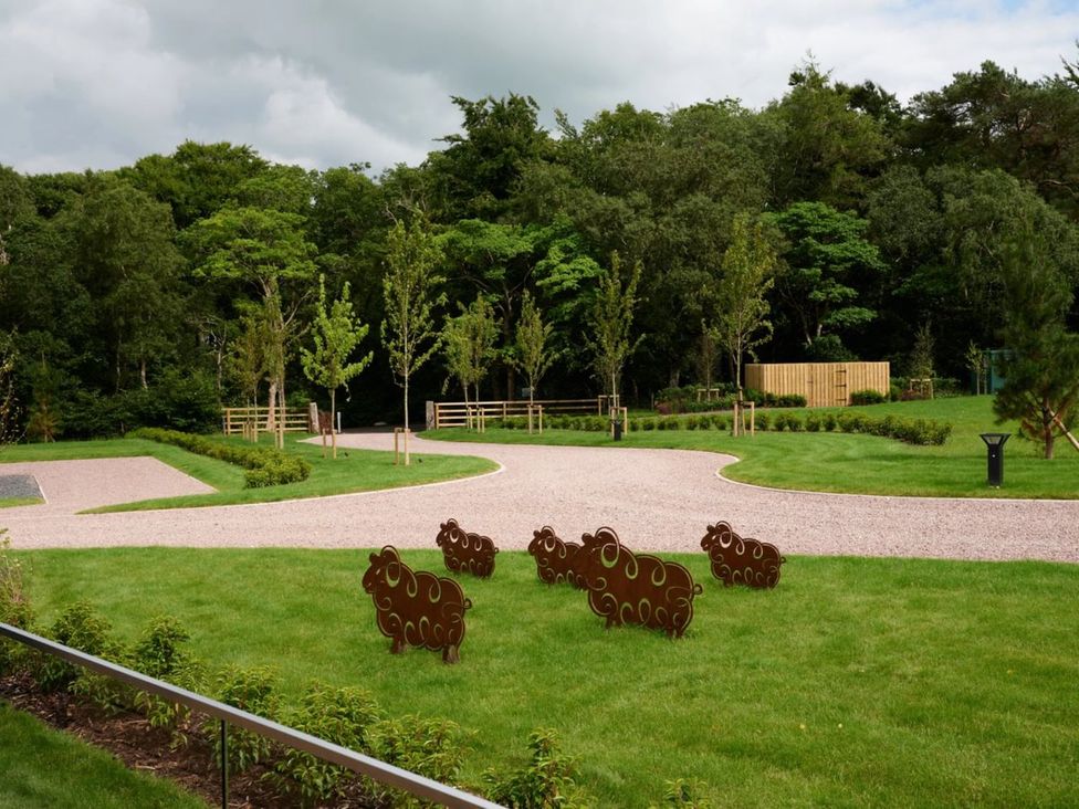 An outdoor area with sheep sculptures and trees at The Whitbarrow Den in Penrith