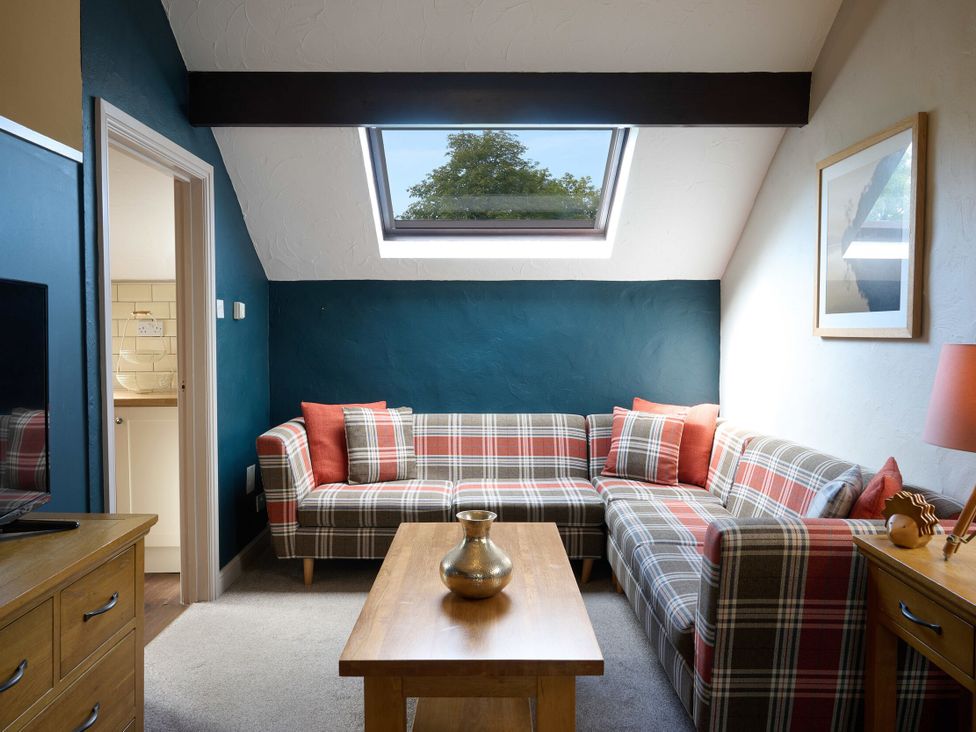 A living room with a sofa and table at Caldew Cottage Spa Penrith