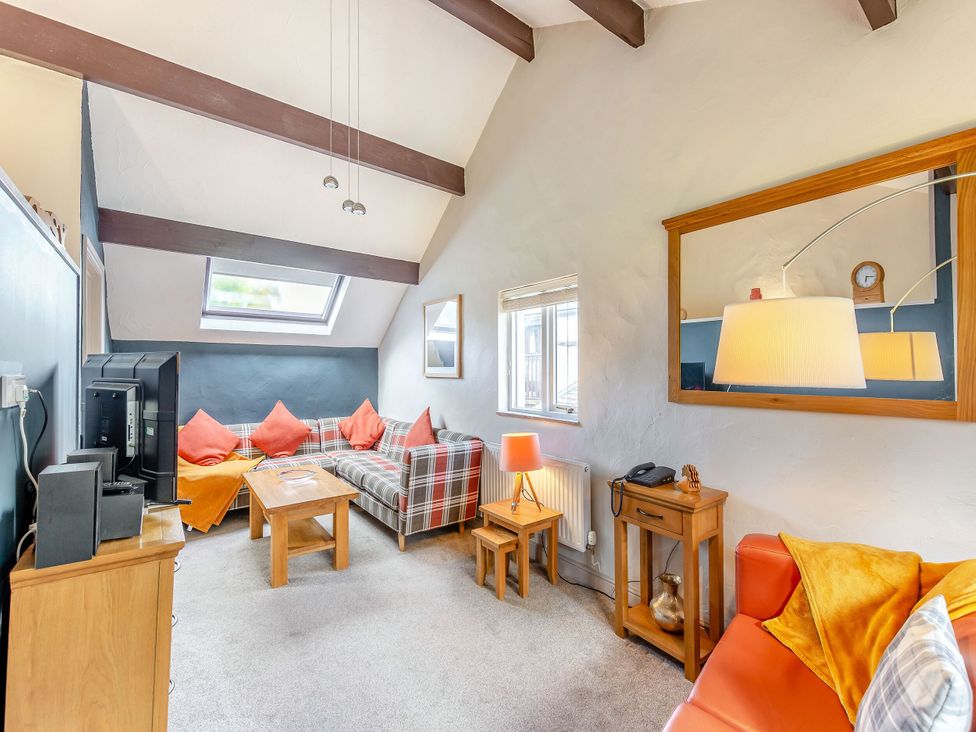 A living room with a sofa and television at Caldew Cottage Spa Penrith
