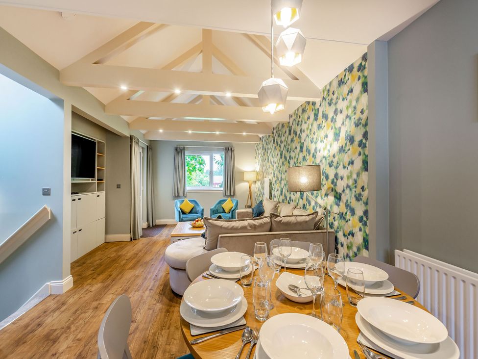 A dining area with a table set for meals at Troutbeck Cottage Spa in Penrith