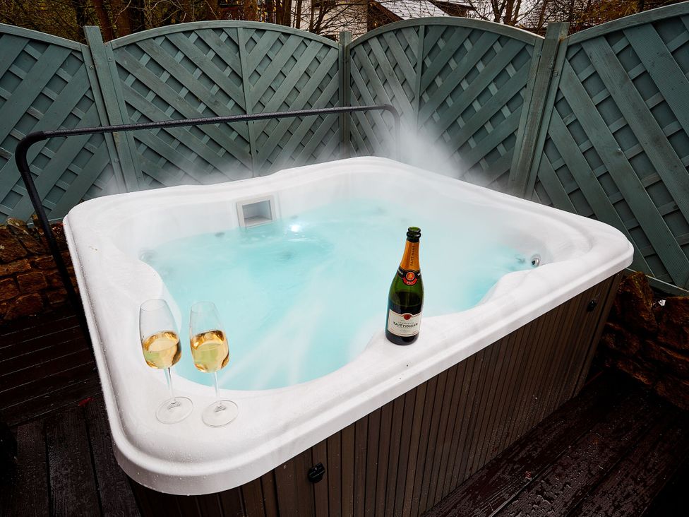 A hot tub with champagne and glasses at The Troutbeck Den Spa Penrith