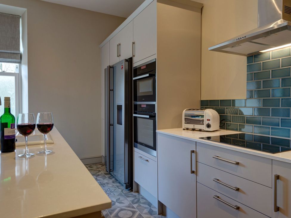 A kitchen with wine glasses and a bottle at The Farmhouse 2 Penrith