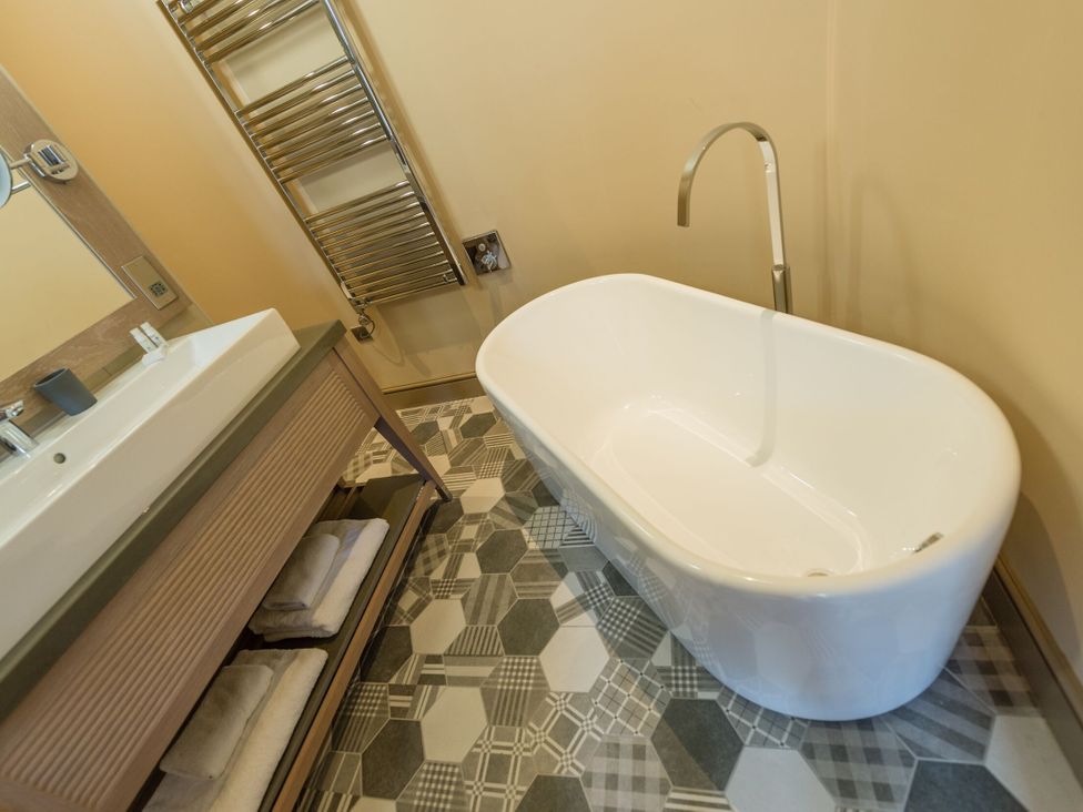 A bathtub and washbasin in a bathroom at The Farmhouse 2 Penrith