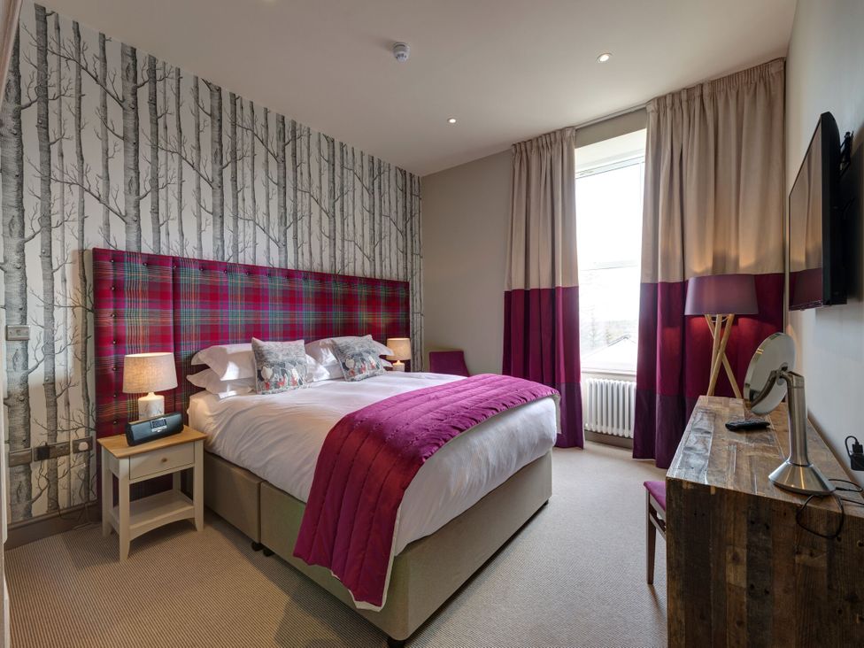 A bedroom with a double bed and bedside lamps at The Farmhouse 2 in Penrith