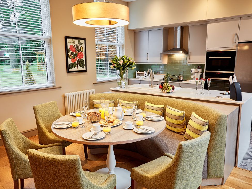 A kitchen with a circular table and chairs at The Farmhouse 1 Penrith