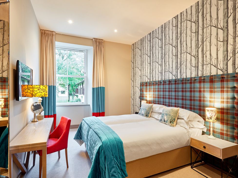 A bedroom with a bed, desk, and window at The Farmhouse 1 Penrith