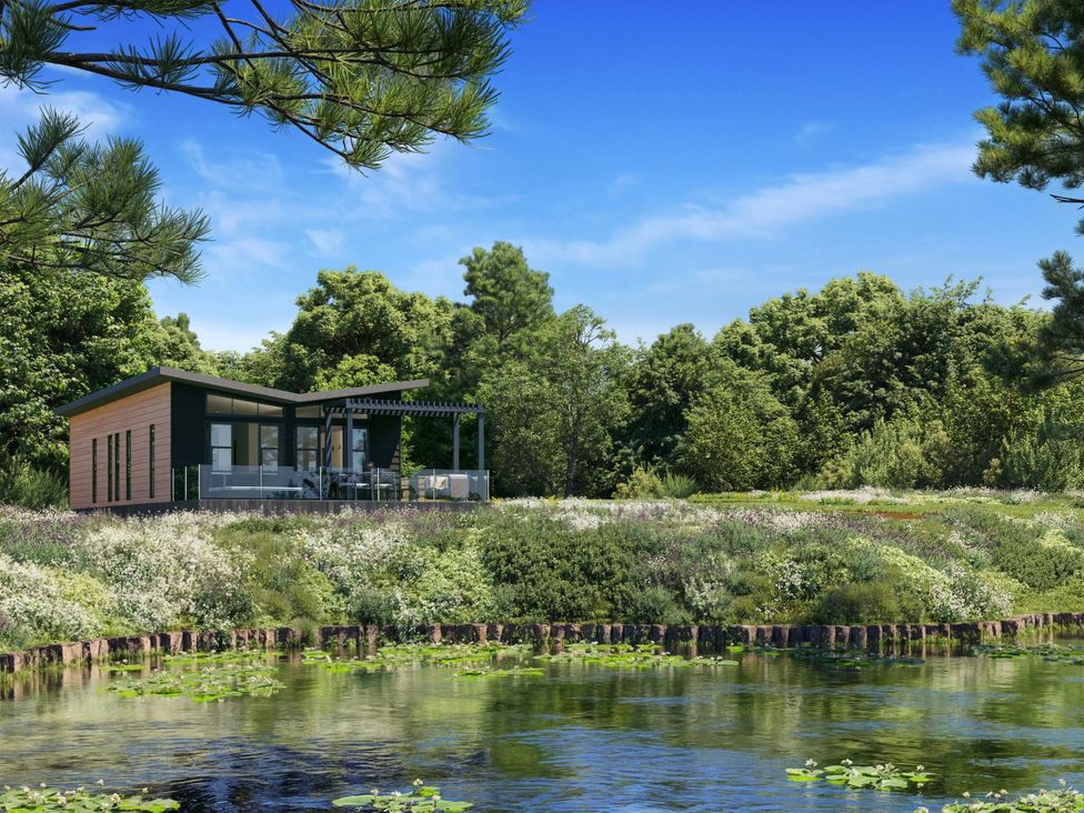A house with a deck beside a water body at Peak View in Penrith