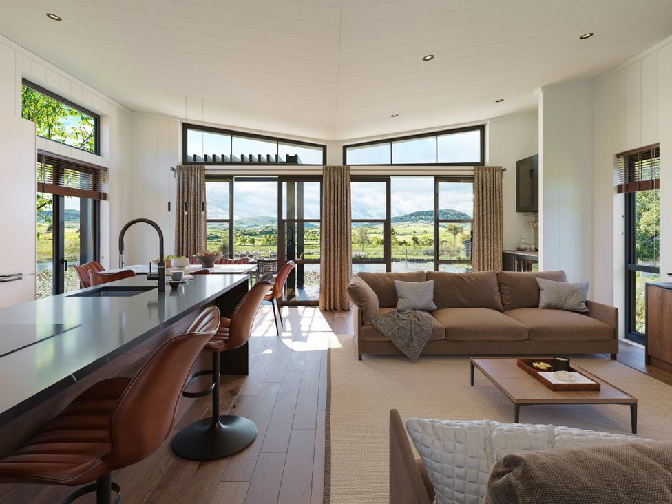 A living room with a sofa and kitchen island at Peak View in Penrith
