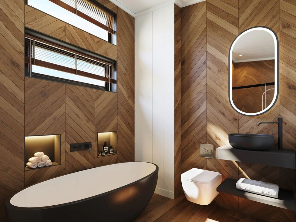 A bathroom featuring a bathtub, toilet, and mirror at Peak View in Penrith