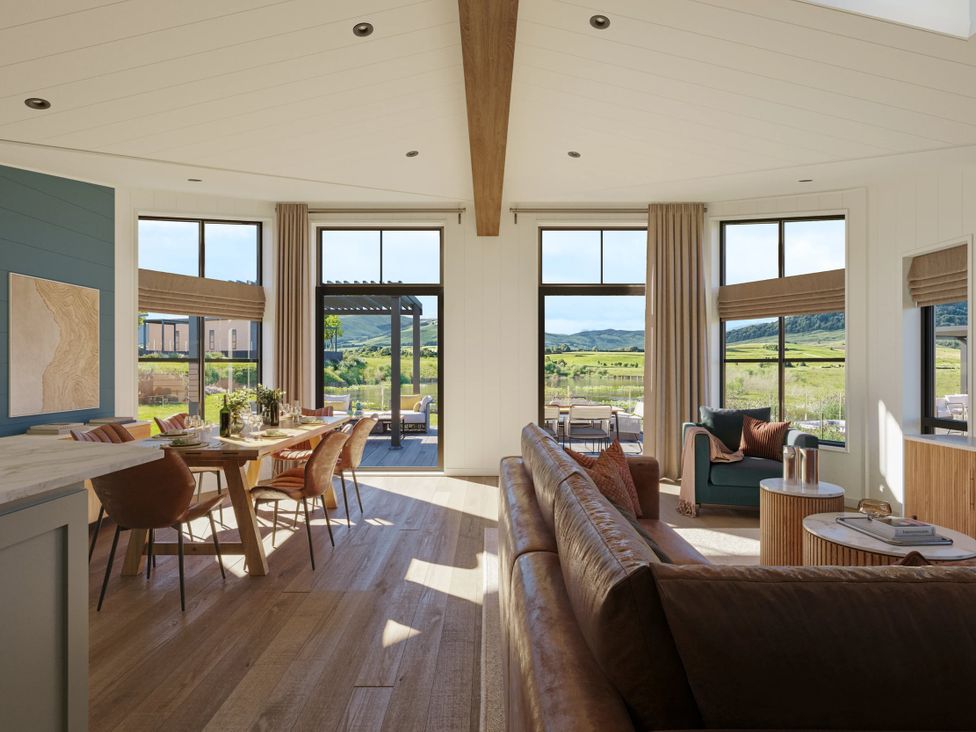 A living room with a sofa and dining area at Wansfell in Penrith