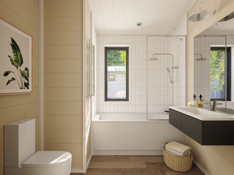 A bathroom with a bathtub and mirror at Lonscale in Penrith