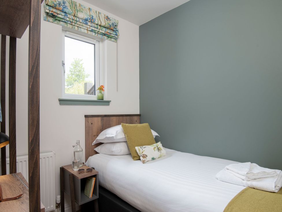 A bedroom with a bed and bedside table at Patterdale (Pet) in Penrith