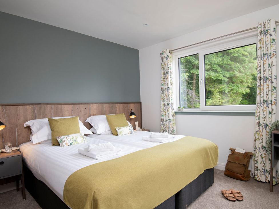 A bedroom with two beds and a window at Patterdale (Pet) Penrith