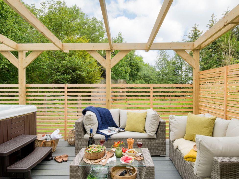 An outdoor seating area with furniture and a hot tub at Patterdale (Pet) Penrith