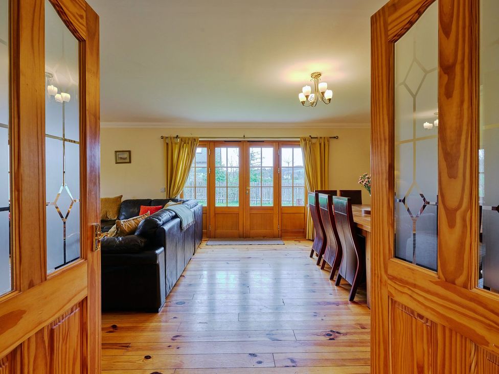 A living room with a sofa and dining table at Holly House in Blairgowrie