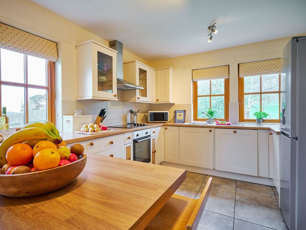 A kitchen with a fruit bowl on a table at Holly House in Blairgowrie