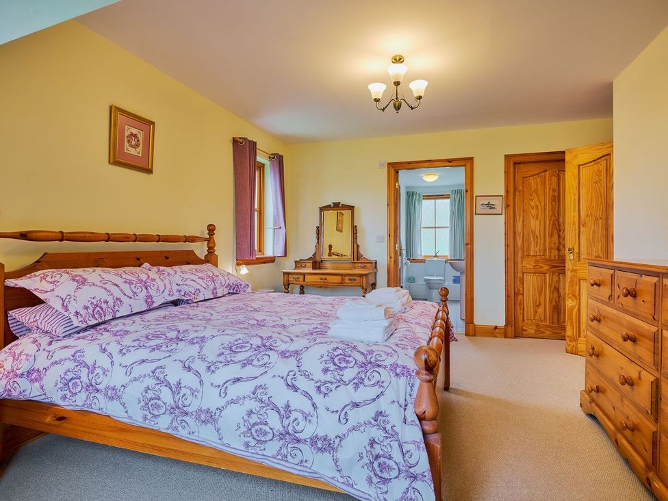 A bedroom with a bed and a dresser at Holly House in Blairgowrie