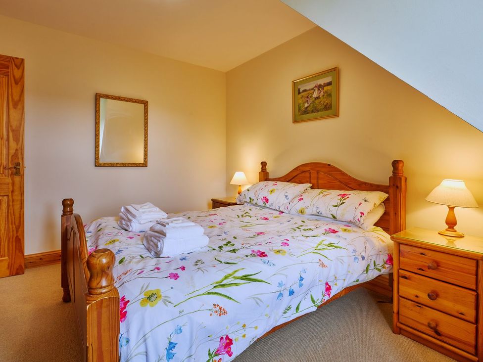 A bedroom with a bed and bedside tables at Holly House in Blairgowrie