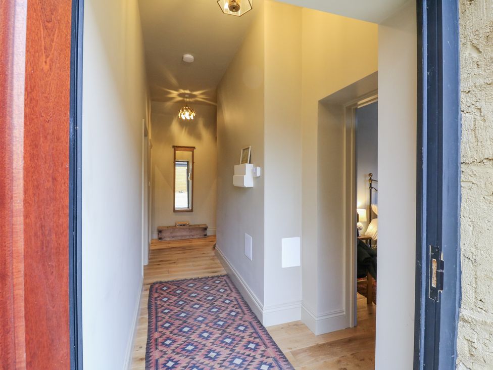 A hallway with a mirror and light fixture at The Apartment in Oving near Whitchurch, Buckinghamshire