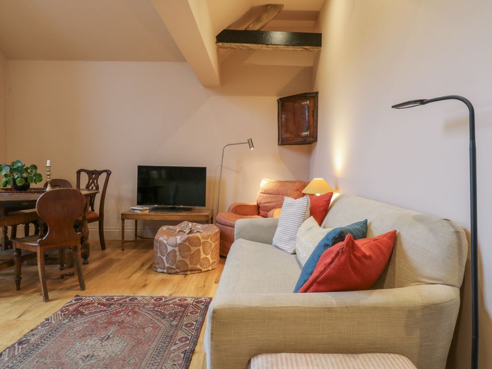 A living room with a sofa and armchair at The Apartment in Oving near Whitchurch, Buckinghamshire