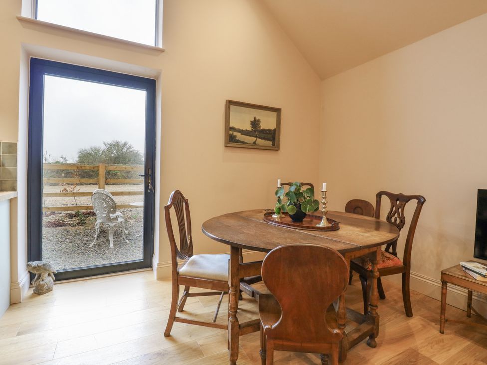 A dining room with a round table and chairs at The Apartment in Oving near Whitchurch, Buckinghamshire