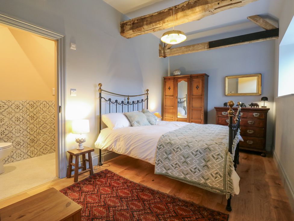 A bedroom with a bed and wardrobe at The Apartment in Oving near Whitchurch, Buckinghamshire