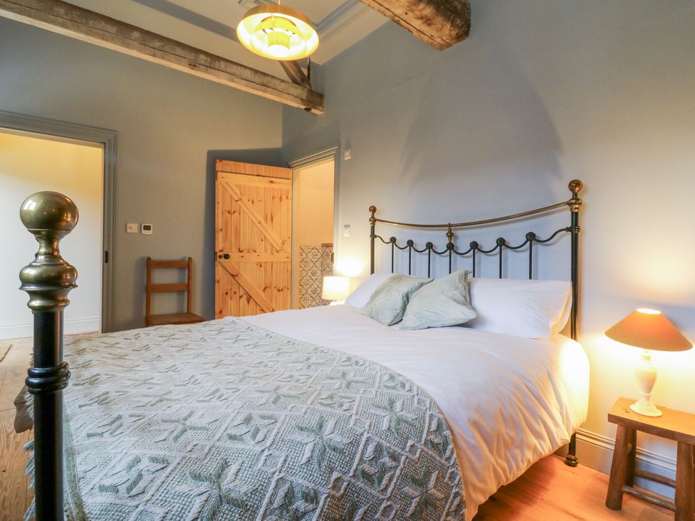 A bedroom with a bed, bedside table and chair at The Apartment in Oving near Whitchurch, Buckinghamshire